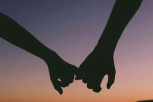 Close-up of hands held tightly, symbolizing trust, emotional support, and human connection as sources of hope.